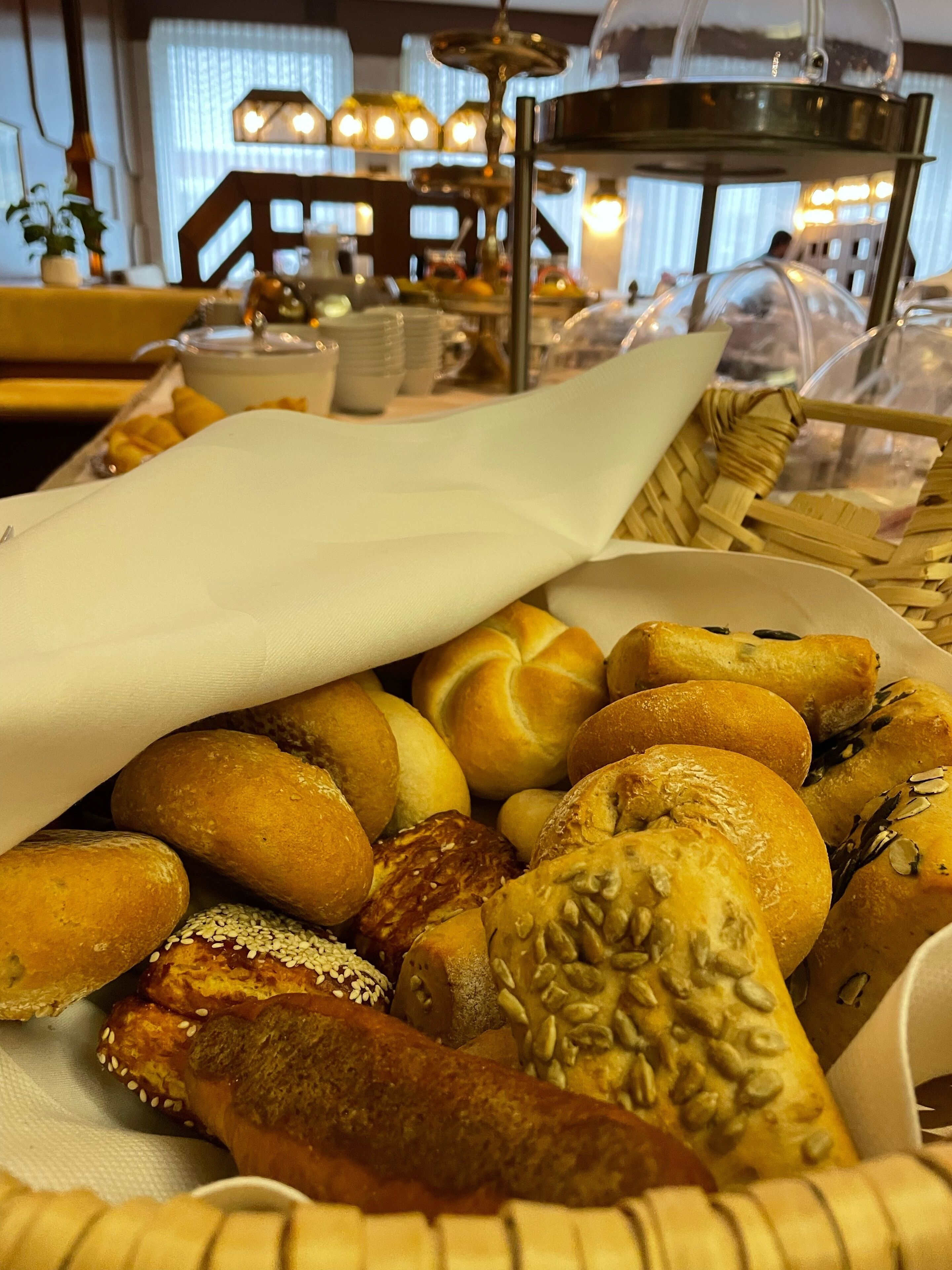 Una variedad de productos horneados, como bollos y pasteles, expuestos sobre una mesa en un restaurante.