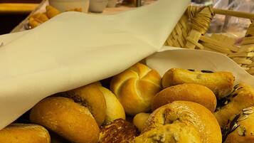 Una variedad de productos horneados, como bollos y pasteles, expuestos sobre una mesa en un restaurante.