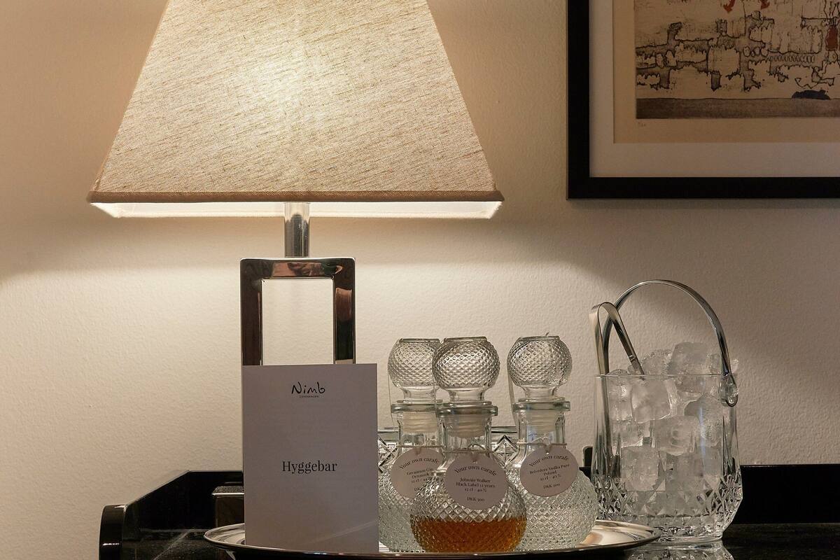 A table with a lamp, ice buckets, and a sign labeled "Nimb Hyggebar."