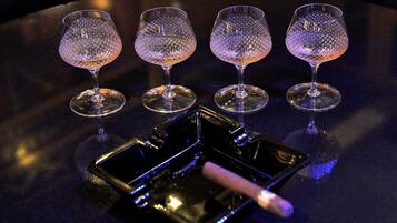 Three clear glass wine glasses on a dark surface with a tray and a smartphone.