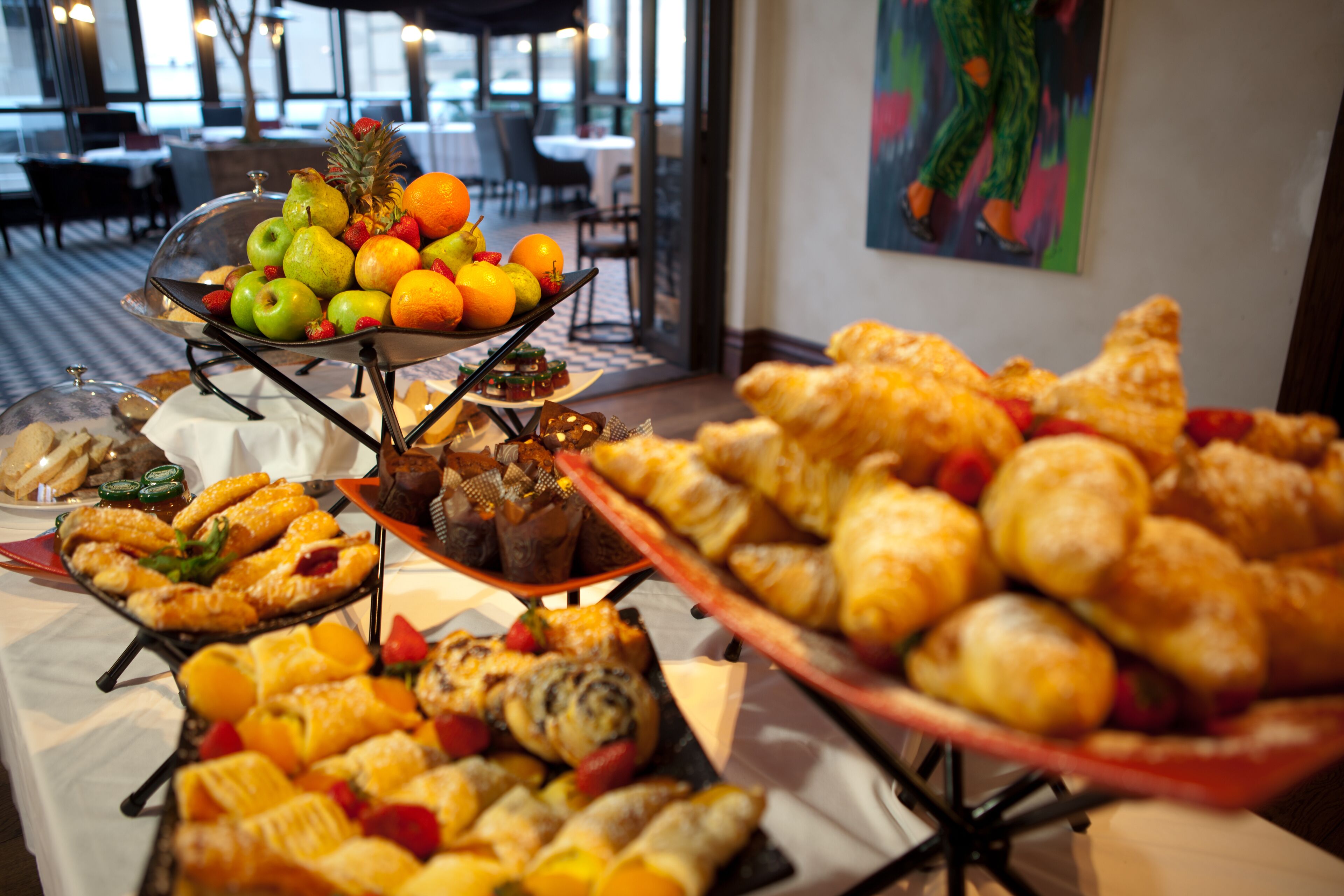 Un bufé con diversos pasteles, frutas y postres.