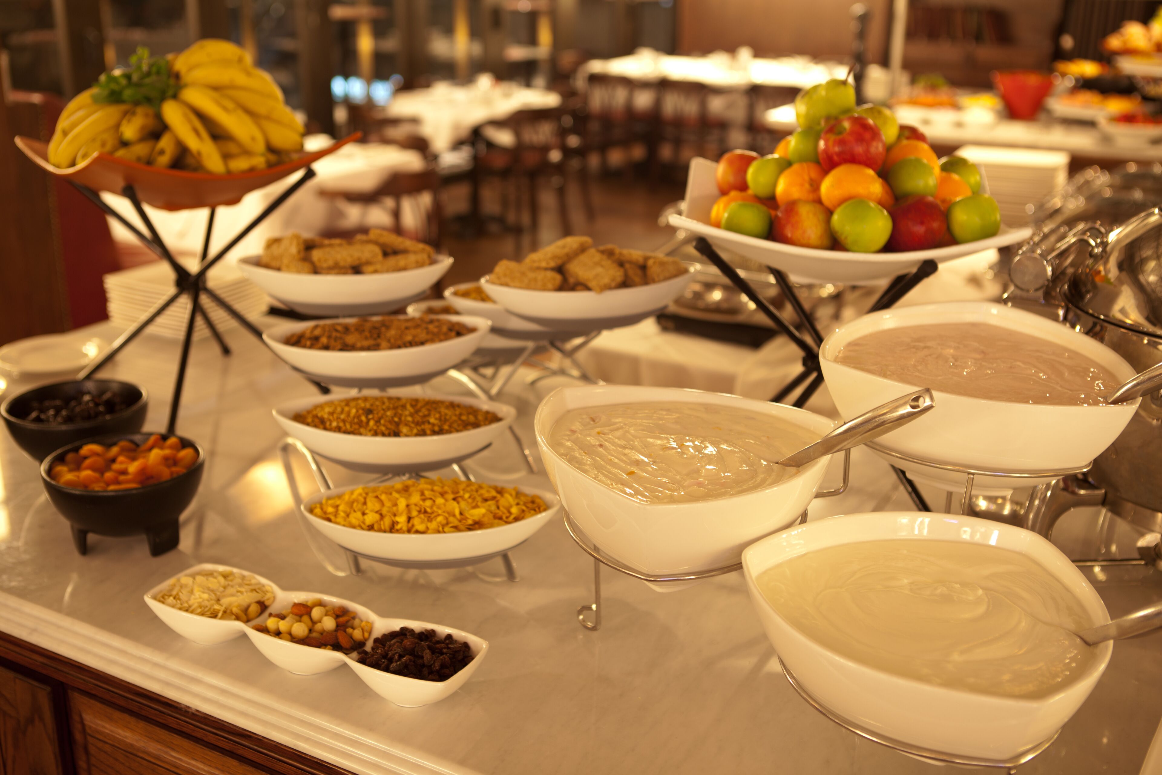 A buffet with various food items including fruits, cereals, and dips.