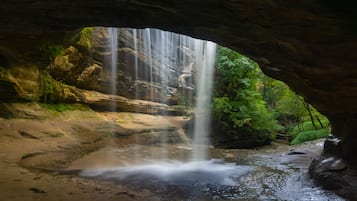 Una cascada dentro de una cueva con un arco natural.