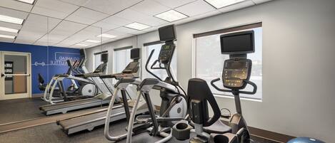 A gym with treadmills, elliptical machines, and a rowing machine.