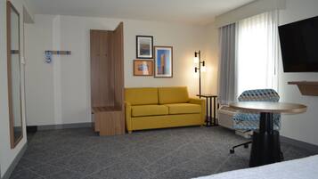 Suite estudio, 1 cama King size | Área de sala de estar | Televisión de pantalla plana de 32 pulgadas con canales premium