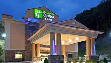 Edifício da Holiday Inn Express & Suites, com entrada coberta e fachada de pedra.