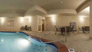 A hotel room with a pool, a dining area, and a reception desk.