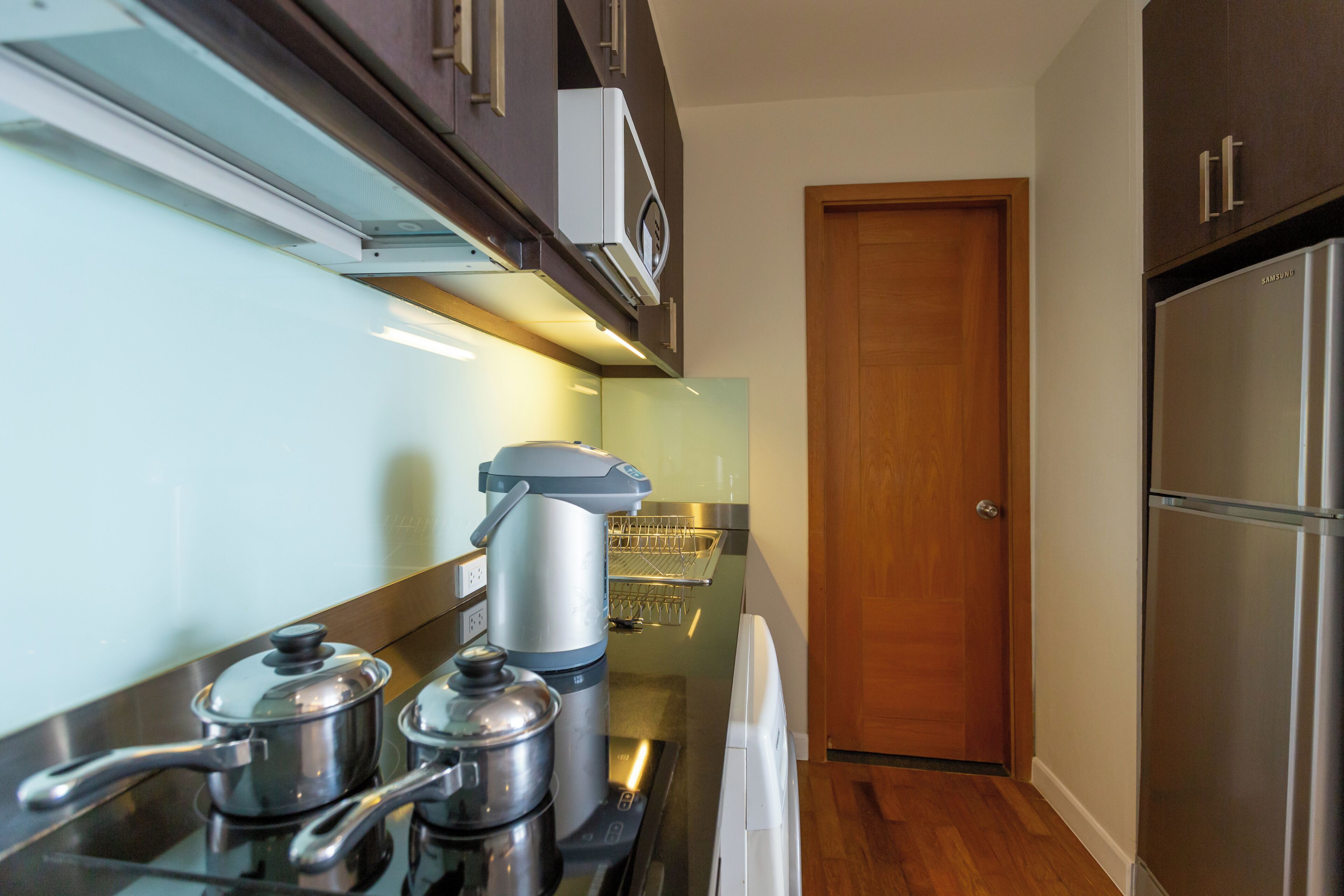 A modern kitchen with stainless steel appliances, a built-in oven, and a refrigerator.