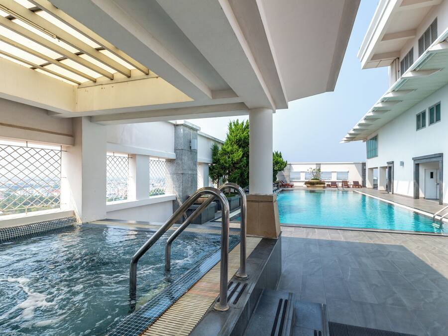 Una piscina interior con agua cristalina, rodeada por un diseño arquitectónico moderno con grandes ventanales y vistas a la ciudad.