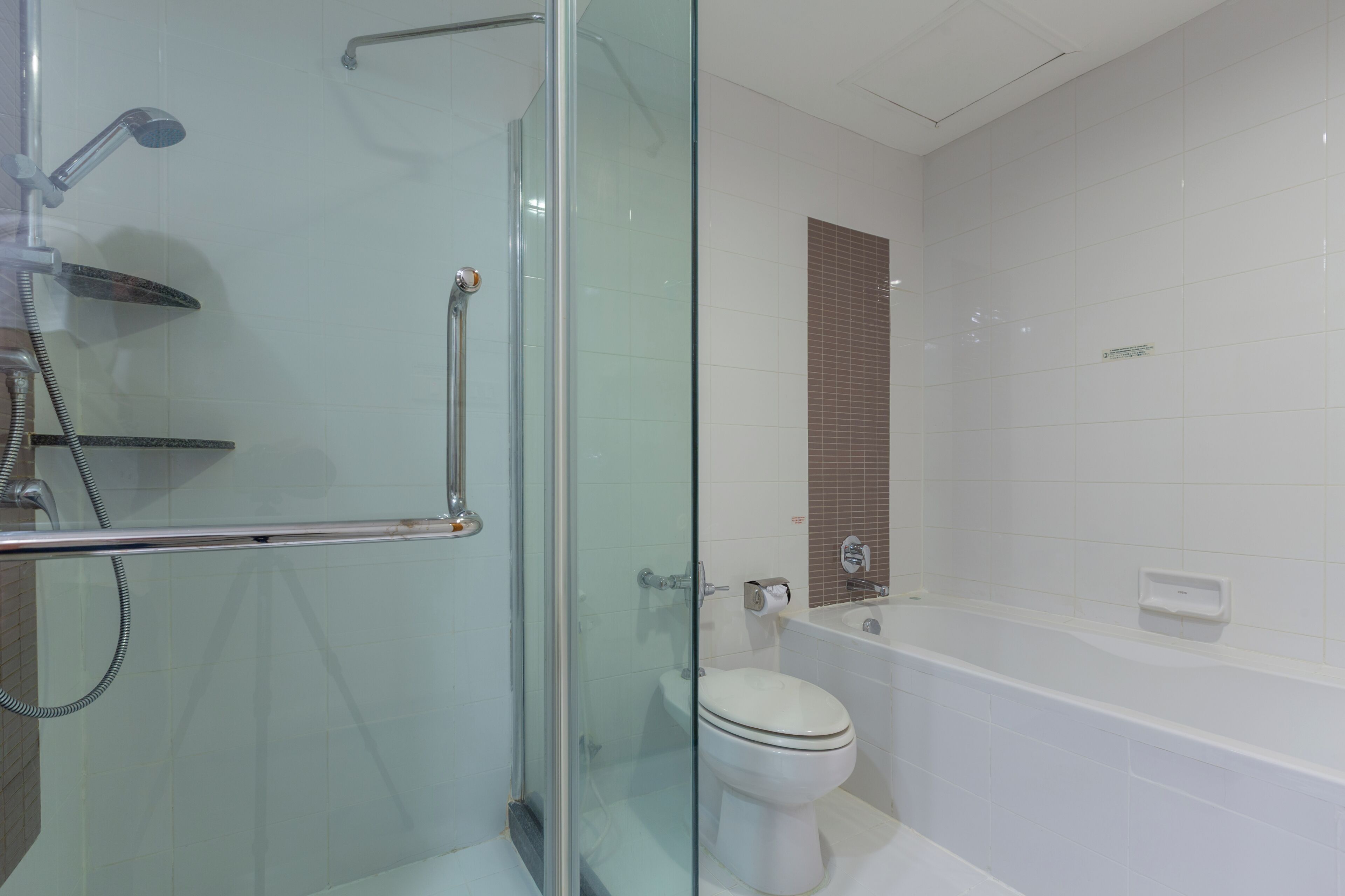 Ein modernes Badezimmer mit einer Duschkabine, einer Toilette und einer Badewanne.