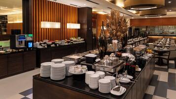 A buffet setup with multiple serving stations, a variety of food items, and a modern interior design.