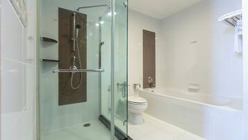 A modern bathroom with a glass-enclosed shower, a white toilet, and a bathtub.