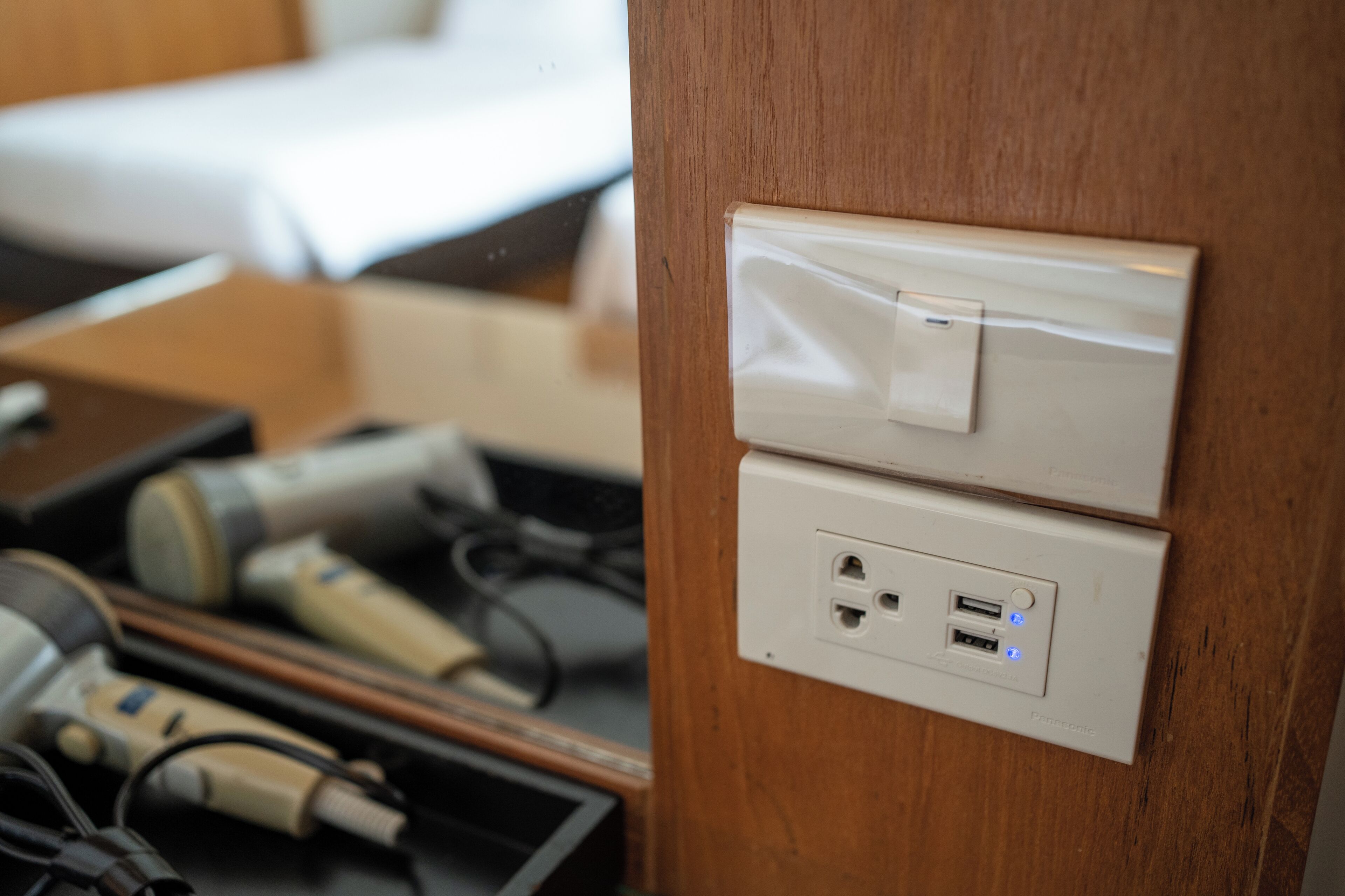 A power outlet with a USB port and a switch on a wooden surface.