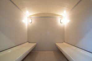 Ein kleines, abgeschlossenes Badezimmer mit zwei Waschbecken und einer Duschkabine.