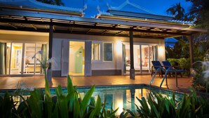 A modern hotel with a pool, covered patio, and traditional architecture.