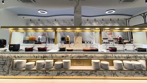 A modern kitchen with marble countertops, a central island with a sink, and overhead lighting. - Nai Yang Beach Resort & Spa (Sa Khu)
