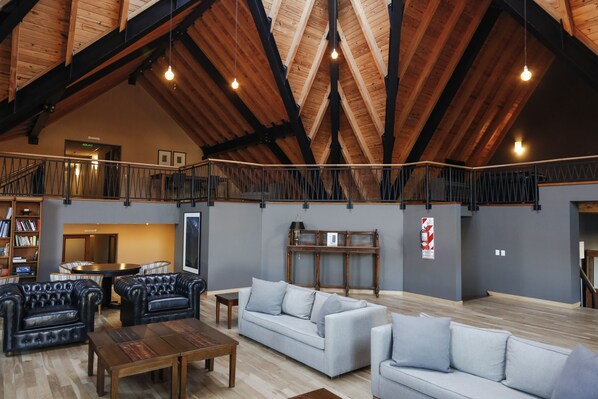 A spacious loft with high ceilings, exposed wooden beams, and a mezzanine level. - Los Cerros del Chalten Boutique Hotel (El Chalten)