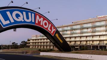 En stor valvöppning med orden ”LIQUI MOLY” och ”MEGUIARS” på, som leder in till en modern byggnad med flera våningar och balkonger.