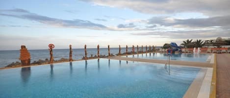 Piscine extérieure, parasols de plage, chaises longues