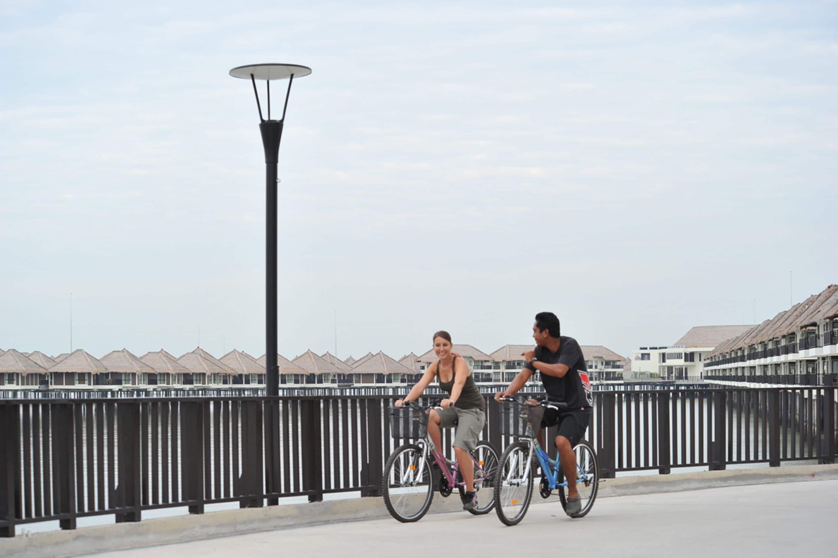 A pedestrian bridge with a metal railing and a street lamp.