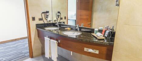 A modern bathroom with two sinks, a large mirror, and a wooden vanity.