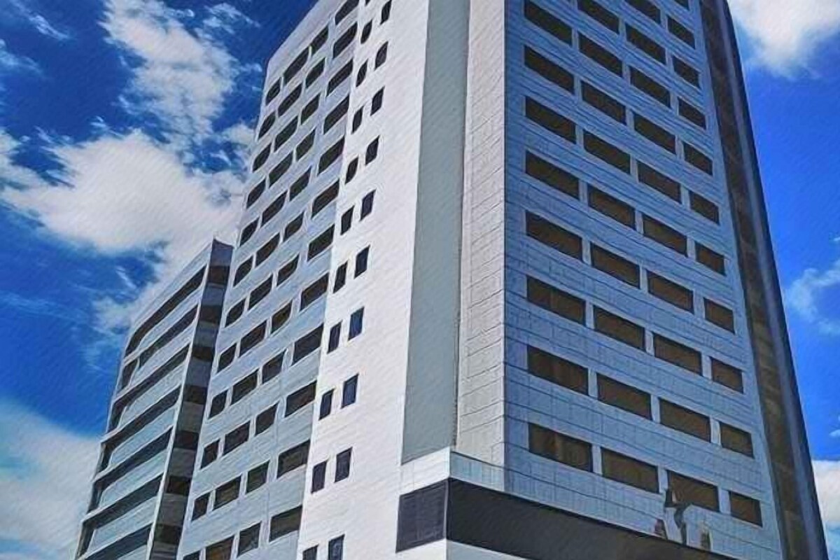 A high-rise building with multiple floors and a clear sky.