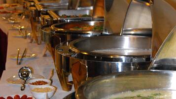 Una mesa de buffet con múltiples recipientes y cubiertos.