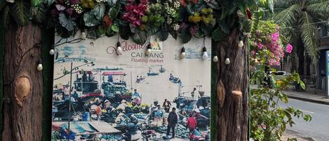 A sign for Kim Tho Hotel with a floating market mural.
