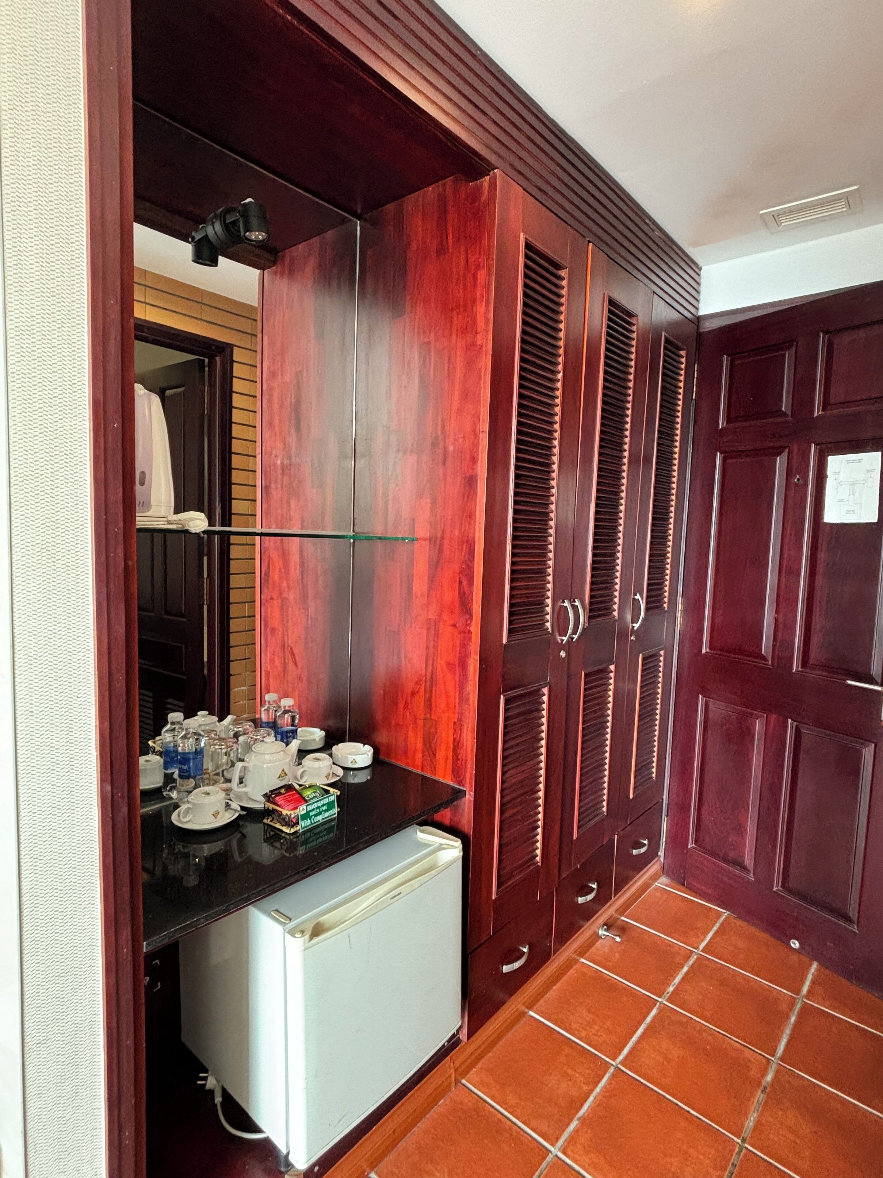 A compact kitchen with a refrigerator, a sink, and a countertop with various items.
