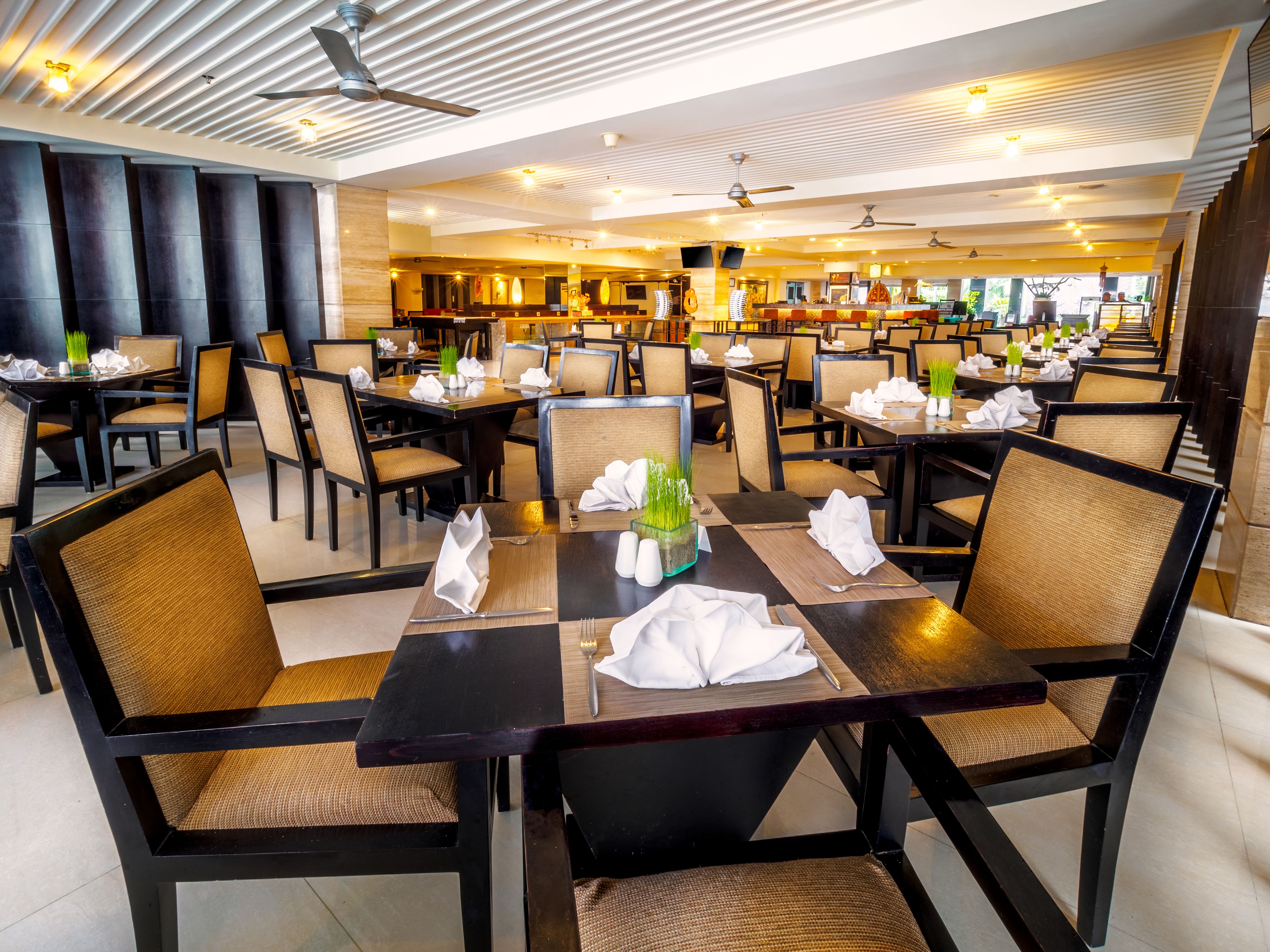 A spacious restaurant with high ceilings, modern lighting, and a clean, organized layout.