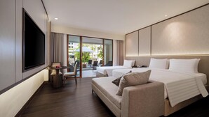 A modern hotel room with a large bed, a sofa, a TV, and a balcony with outdoor seating. - Aston Kuta Hotel & Residence (Kuta)