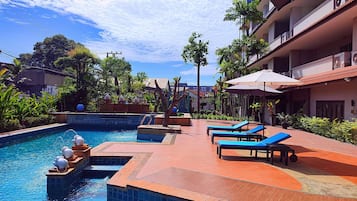 Een buitenzwembad, parasols voor strand/zwembad