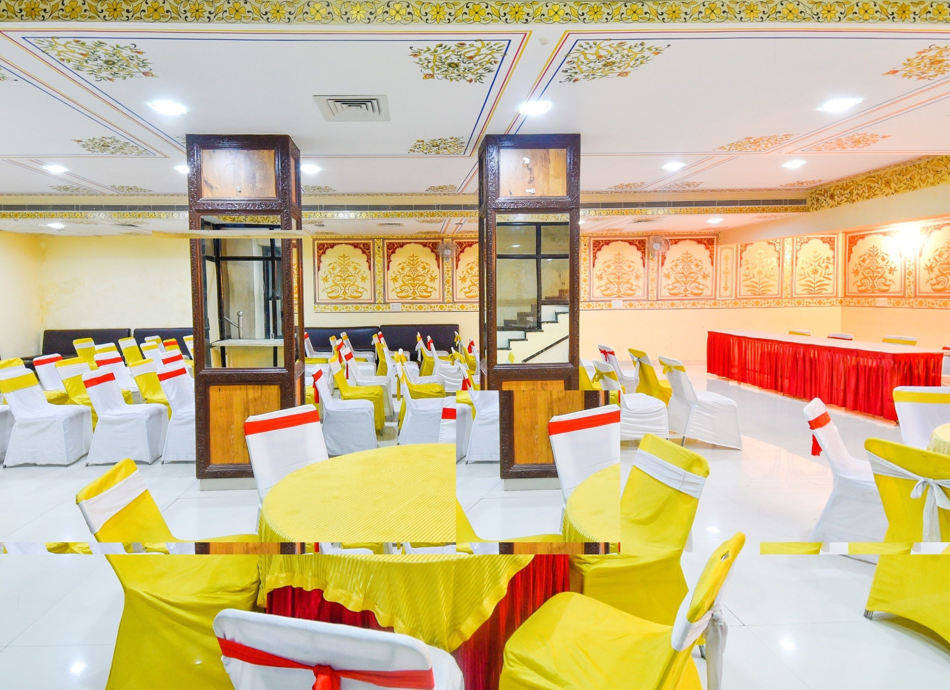 A banquet hall with rows of tables and chairs, ornate ceiling decorations, and a staircase.
