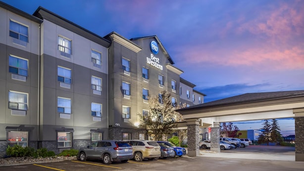 Monikerroksinen hotelli, jonka yläpuolella on kyltti, jossa lukee ”Best Western”, useita autoja sisältävä parkkipaikka ja kirkas taivas.