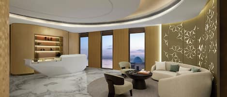 A modern lobby with a reception desk, seating area, and large windows.