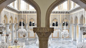 Un intérieur somptueux, avec de hauts plafonds, des fenêtres en arc de cercle et des motifs complexes sur les murs.