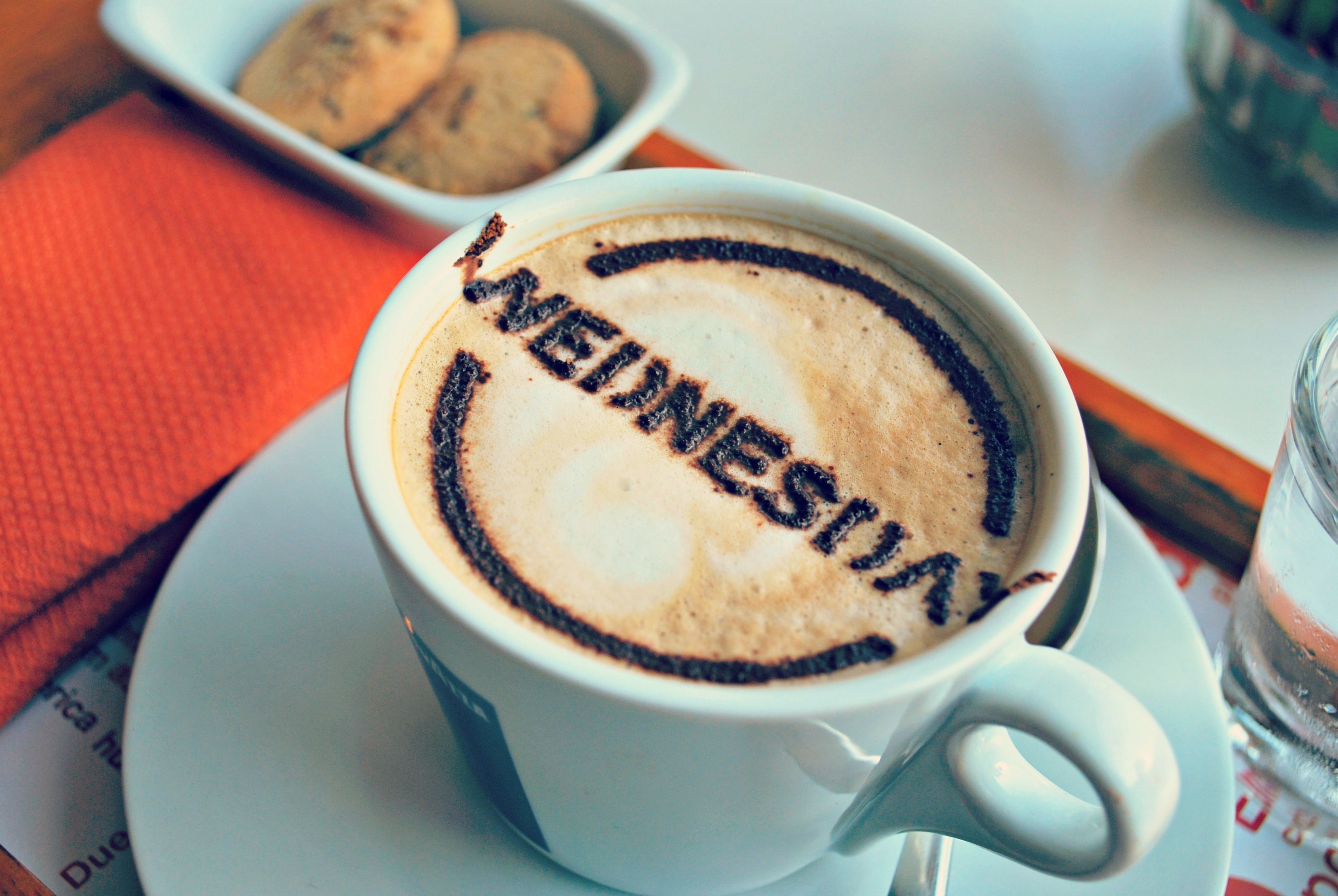 A cup of coffee with "WEDNESDAY" written on the foam.