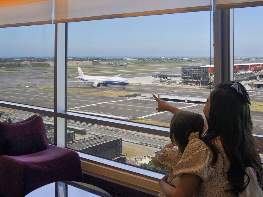 A view from a window at an airport, featuring a large airplane on the tarmac.