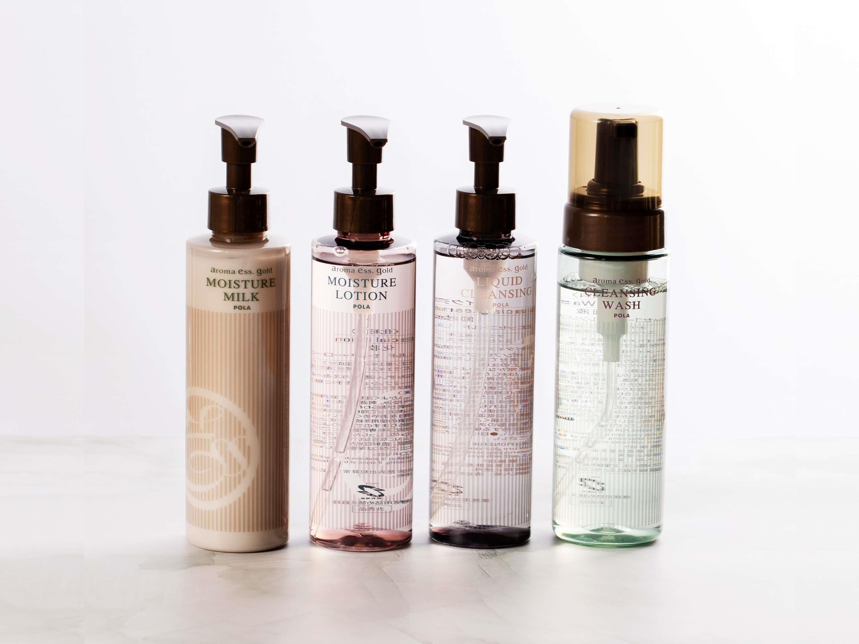 Cuatro botellas de productos para el cuidado de la piel con dispensadores, cada una con una etiqueta distinta.