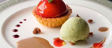 Une assiette de dessert avec une tarte, une glace et une sauce.