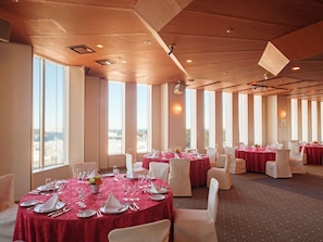 A banquet hall with round tables, white chairs, and red tablecloths. - Mercure Yokosuka (Yokosuka)