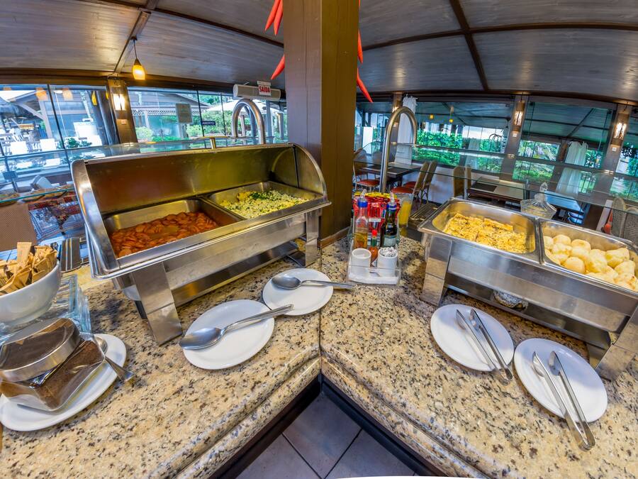 A buffet area with various food stations, including a salad bar, a hot dish station, and a cheese station.