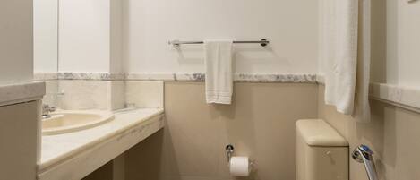 Un baño pequeño y funcional con inodoro, lavabo y perchero para toallas.