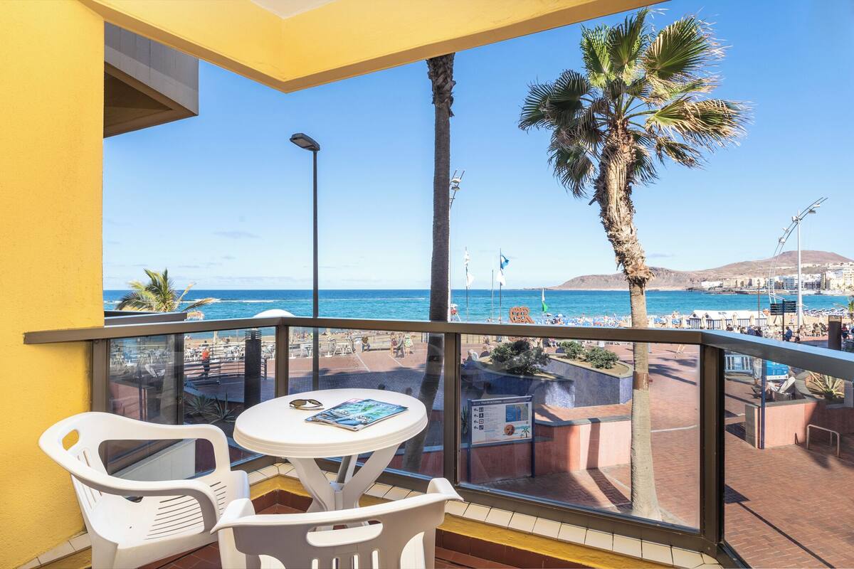 Ein Balkon mit freiem Blick auf Strand und Meer.