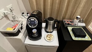 A compact kitchenette with a coffee maker, a kettle, and a small plate of gold bars. - Bed & Bed Cassia (Florence)