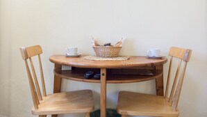 A wooden table with two chairs, a basket, and two cups on a placemat. - Bed & Bed Cassia (Florence)