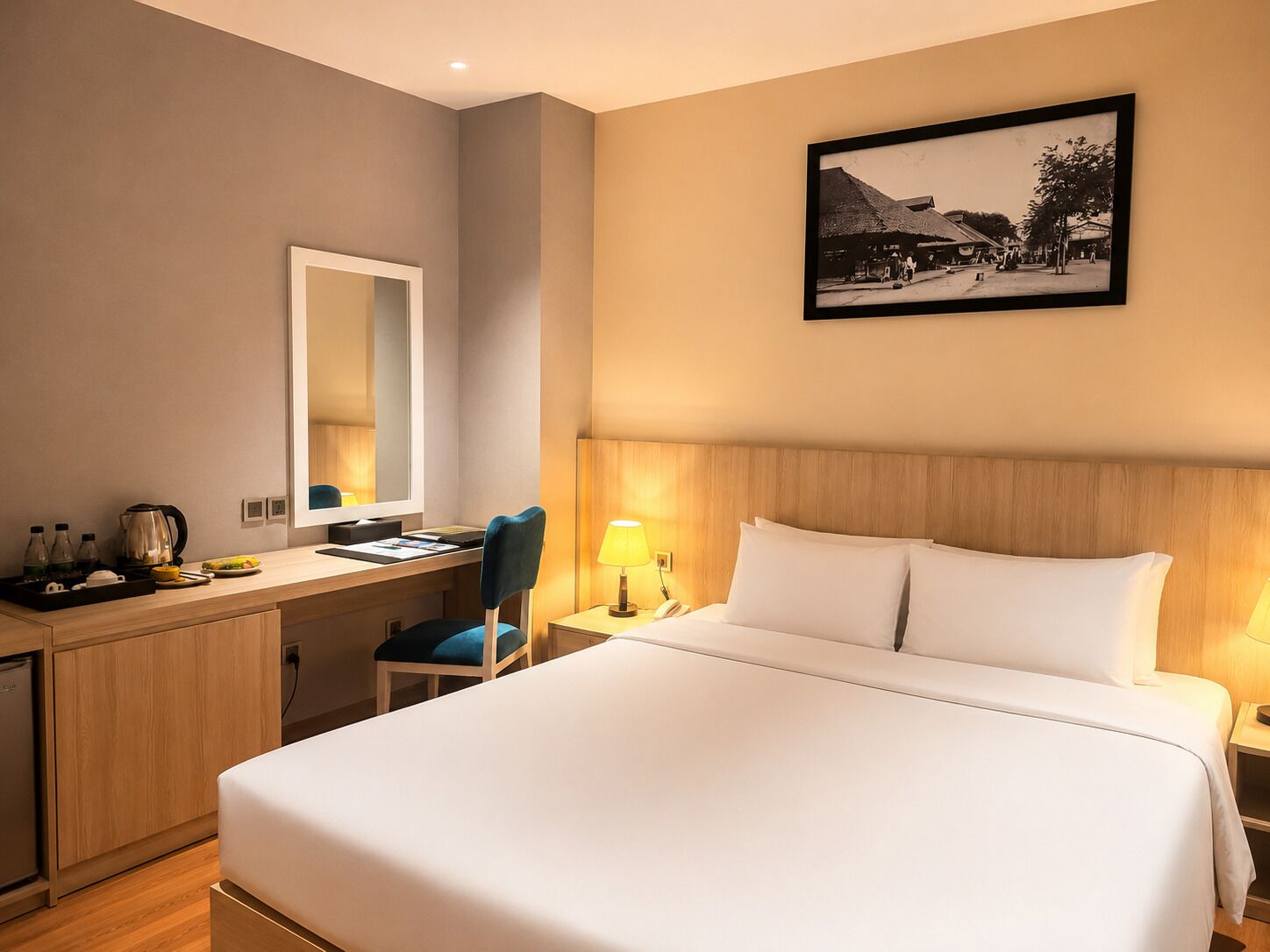 Une chambre d’hôtel avec un lit, un bureau, une chaise et un tableau accroché au mur.
