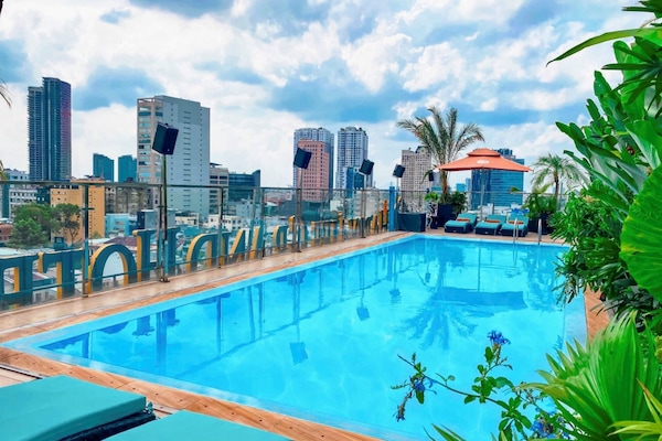 Una piscina al aire libre, tumbonas