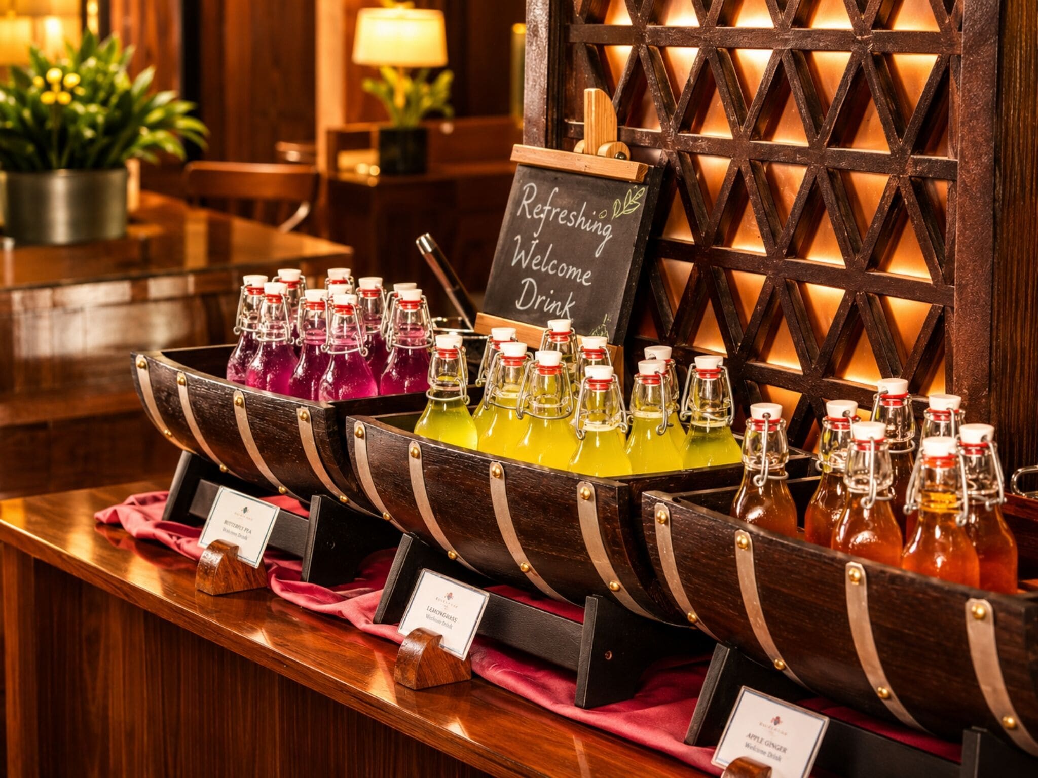 A bar area with a chalkboard sign reading 'Refreshing Welcome Drink' and a selection of bottled beverages.