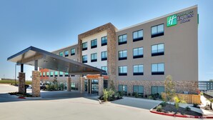 Een Holiday Inn Express & Suites gebouw met een overdekte ingang, meerdere verdiepingen en een brandgang.